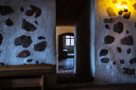 Old castle interior with antique furniture, stone walls, and warm light creating a medieval atmosphere full of history and mystery.の写真素材