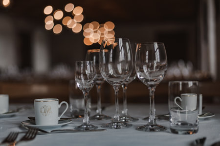 Majestic medieval castle banquet hall with long wooden tables, chandeliers, and stone walls illuminated by warm candlelight, evoking the atmosphere of royal feasts.の写真素材