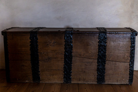 Old wooden chests with metal fittings placed in a medieval castle interior, showing antique...