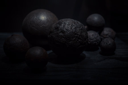 Various antique objects placed in a medieval castle interior, including wooden chests, metal locks, sculptures, old books, and candle holders. Warm light emphasizes textures, historical craftsmanship, and medieval atmosphere. Perfect for heritage, history, and interior photography.の写真素材