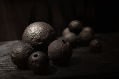 Various antique objects placed in a medieval castle interior, including wooden chests, metal locks, sculptures, old books, and candle holders. Warm light emphasizes textures, historical craftsmanship, and medieval atmosphere. Perfect for heritage, history, and interior photography.の写真素材