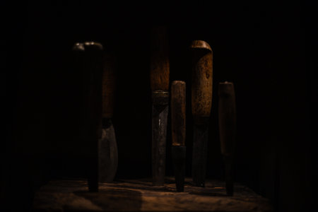 Various antique objects placed in a medieval castle interior, including wooden chests, metal locks, sculptures, old books, and candle holders. Warm light emphasizes textures, historical craftsmanship, and medieval atmosphere. Perfect for heritage, history, and interior photography.の写真素材