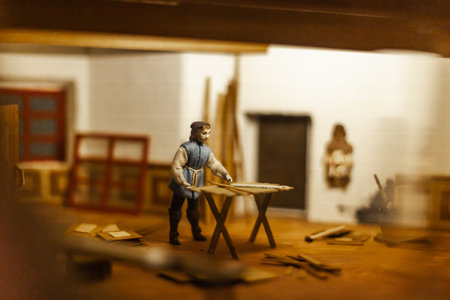 Miniature scenes inside a medieval castle showing figurines of knights, peasants, and nobles in daily life. Artistic staged display symbolizing history and craftsmanship.の写真素材