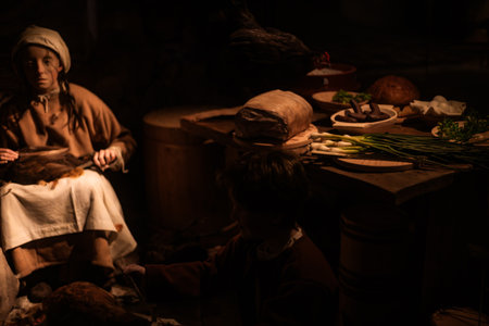 Miniature scenes inside a medieval castle showing figurines of knights, peasants, and nobles in daily life. Artistic staged display symbolizing history and craftsmanship.の写真素材