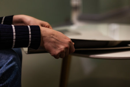 Close-up photograph of human hands flipping through a magazine. Clear details of the paper, texture, and page movement. Perfect for lifestyle imagery, education, reading habits, print media, and editorial themes.の写真素材