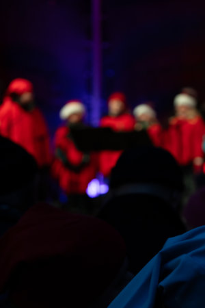 Photo of children performing on stage during a New Year concert, singing under festive lights and holiday decorations.の写真素材