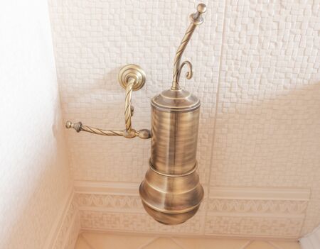 bronze toilet brush hanging on the wallの写真素材