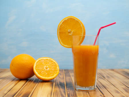 Orange juice in a glass with a slice of orange and an straw.の写真素材