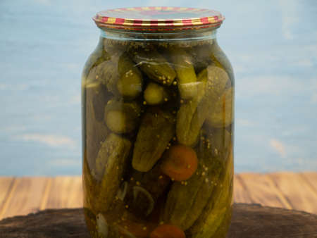 Preservations, conservation. Salted, pickled cucumbers in a jar on an wooden table. Pickling cucumbers at home. Vegetable harvest conservation. close up.の写真素材