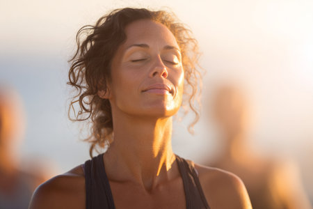 Participants engage in a peaceful yoga session on the beach at sunset, focusing on breathing and mindfulness, creating a calming and serene atmosphere.の素材