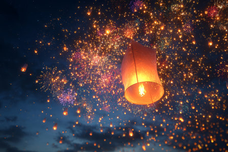 Bright lanterns float through the dark sky, surrounding colorful fireworks that burst and sparkle. This magical scene captivates onlookers during a joyful celebration at night.の素材