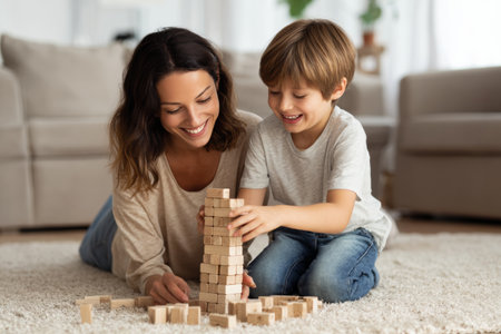 A mother and her young son are happily engaged in stacking wooden blocks. They sit on a soft carpet in a bright living room filled with natural light. The atmosphere is cheerful and nurturing.の素材