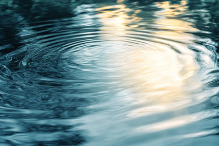 Gentle ripples dance across a smooth water surface, capturing soft reflections of light during the serene moments of sunset, conveying a sense of peace and tranquility.の素材