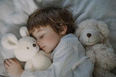 A child rests peacefully in bed, embraced by a fluffy teddy bear and a soft plush animal. The serene atmosphere highlights a sense of safety and comfort during nighttime.の素材
