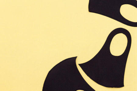 black face masks protect viruses on the yellow background.の写真素材