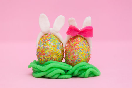 Cute funny handmade eggs bunny on pink background. Easter holiday creative concept.の写真素材