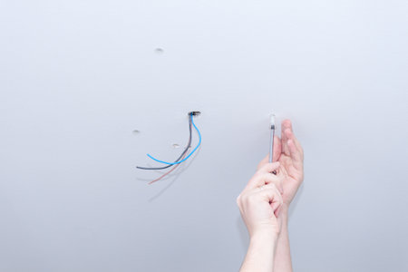 Electrician assembles electrical wiring for lampの写真素材