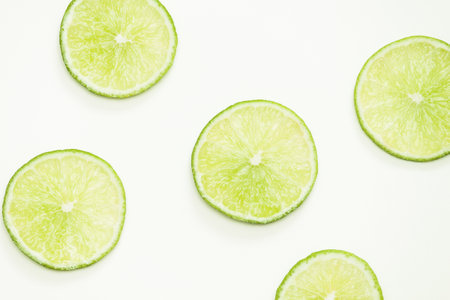 Composition with fresh circle limes on light background, top view, close up.の写真素材