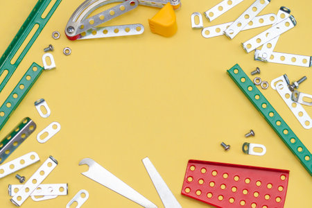 Metal, iron constructor on the yellow background. Parts of kids metal designer for modeling.の写真素材