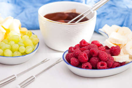Fondue with melted chocolate, fruits and berries.の写真素材
