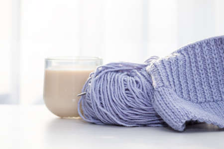 A peace of lilac knitting with knitting needles. Female hobby and leisure knitting concept.の写真素材
