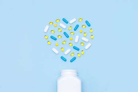 Different tablets and capsules in shape of heart. Healthy life concept, supplements, vitamins.の写真素材