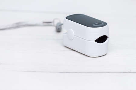 Pulse oximeter for measure pulse rate and oxygen level on white wooden table. Healthy concept.の写真素材