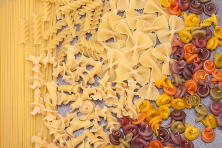 Various types of raw Italian pasta on the wooden rustic backgroundの写真素材