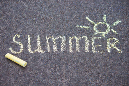 Yellow chalk drawing on asphalt text summer with sun.の写真素材
