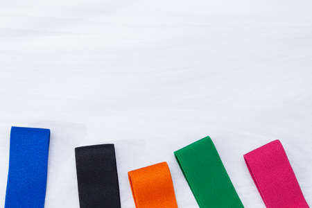 A set of multi-colored elastic rubber bands for fitness on white wooden background. Fitness trend, sport concept.の写真素材