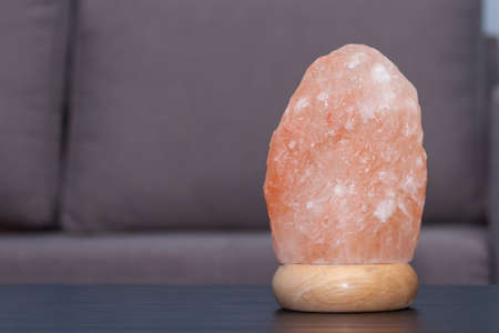 Himalayan pink salt lamp on table indoorsの写真素材