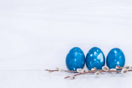 Three blue space galactic Easter eggs on white wooden background. Close up. Easter greeting card. Copy space.の写真素材