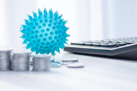 Impact of Coronavirus on the economy. Coins, calculator on the desk. Medicine and money concept, expenses for covid-19.の写真素材