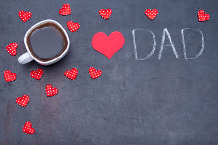Cup of black coffee for father, hearts on black background. I love you DAD concept. Flat lay, copy...