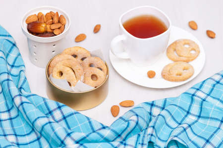 Homemade smile cookies with cup of black tea on white wooden background. Good morning or have a nice day concept. Flat lay.の写真素材