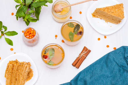 Tea with sea buckthorn, mint, honey, cinnamon, honey layered cake medovik.の写真素材