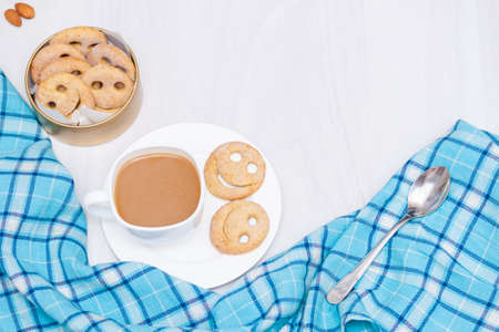Homemade smile cookies with cup of coffee on white wooden background. Good morning or have a nice day concept. Flat lay, copy space.の写真素材