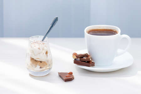 Cup of coffee, milk chocolate with nuts, ice cream with chocolate powder. Summer eat and drink for refreshment.の写真素材