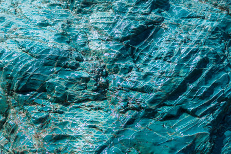 Blue green rock background. Turquoise cracked mountain surface. Stone background, copy space.