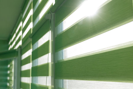 Close up of colored fabric roller blinds on window. Roll curtains.の写真素材