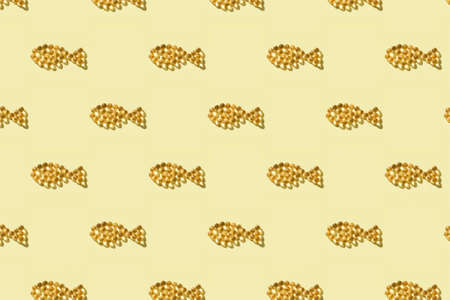 Seamless pattern from fish oil capsules in fish shape on yellow background.の写真素材