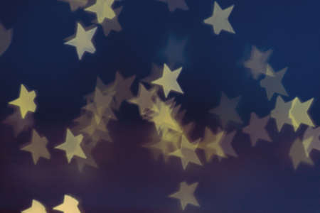 Golden stars light bokeh background. Christmas abstract pattern.