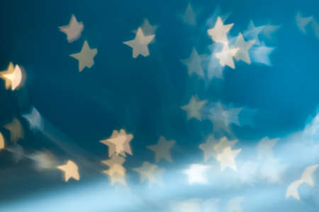 Golden stars light bokeh background. Christmas abstract pattern.の写真素材