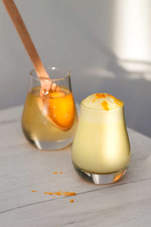 Glass with turmeric powder with honey. Healthy ayurvedic drink, detox beverage. Copy spase.の写真素材