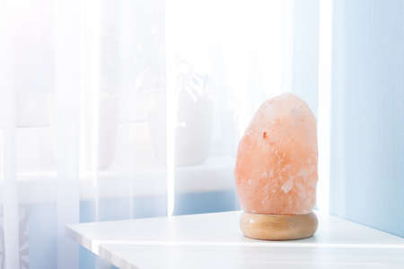 Pink himalayan rock lamp on white table in sunny day.の写真素材