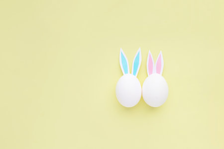 Easter eggs with handmade paper ears on yellow background. nature concept.の写真素材