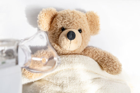 Ill toy bear with nebulizer mask, flu, asthma, pneumonia concept.の写真素材