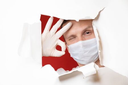Coronavirus. Business man, wears a protective mask. A business man in a coronavirus quarantine wears a protective mask. Work at home. Cleans hands with disinfectant gel. No virus.の写真素材