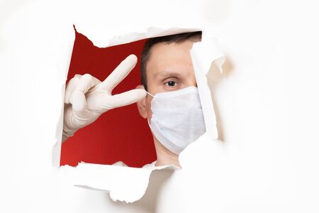Coronavirus. Business man, wears a protective mask. A business man in a coronavirus quarantine wears a protective mask. Work at home. Cleans hands with disinfectant gel. No virus.の写真素材