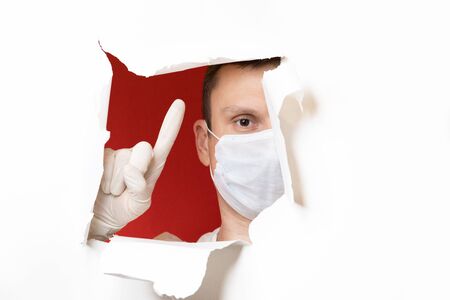 Coronavirus. Business man, wears a protective mask. A business man in a coronavirus quarantine wears a protective mask. Work at home. Cleans hands with disinfectant gel. No virus.の写真素材
